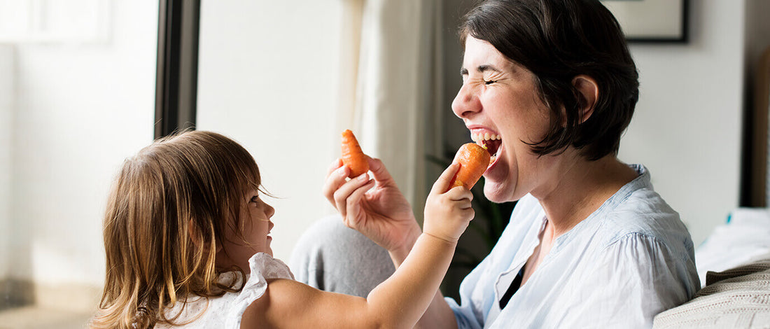 Women and child eating carrots