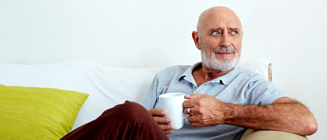 Lively older gentleman sitting drinking coffee